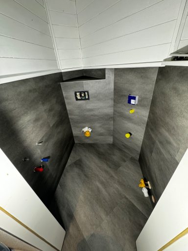 Kleine, moderne Dusche mit grauen Wänden und bunten Deko-Elementen.