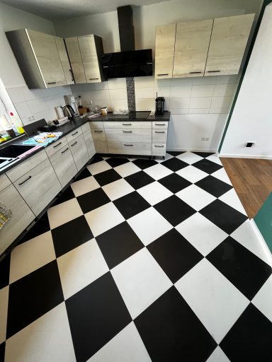 Moderne Küche mit grauen Schränken und schwarz-weißer Schachbrettfliesenboden.