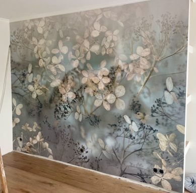 Wand mit floralem Muster in sanften Farben, leicht verschwommen und elegant.
