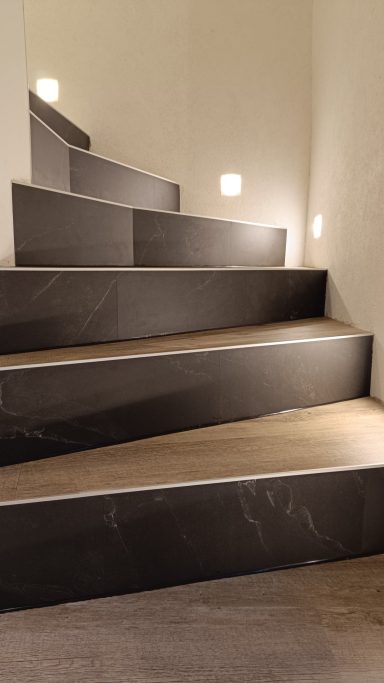 Dunkle Treppe mit sanfter Beleuchtung an den Wänden.