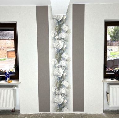 Zimmer mit dekorativen Wänden in Grau und einer Blütenornamentik in der Mitte.