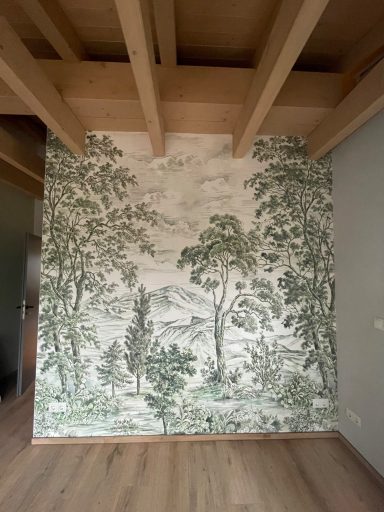 Wand mit einem grünen Waldmotiv und Ausblick auf Berge, unter Holzdeckenbalken.