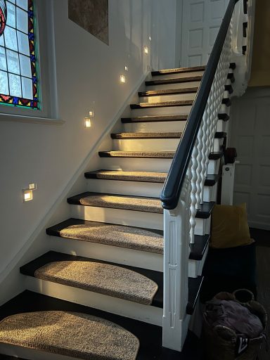 Helle Treppe mit Sonnenlicht und bunten Lichtreflexionen auf den Stufen.